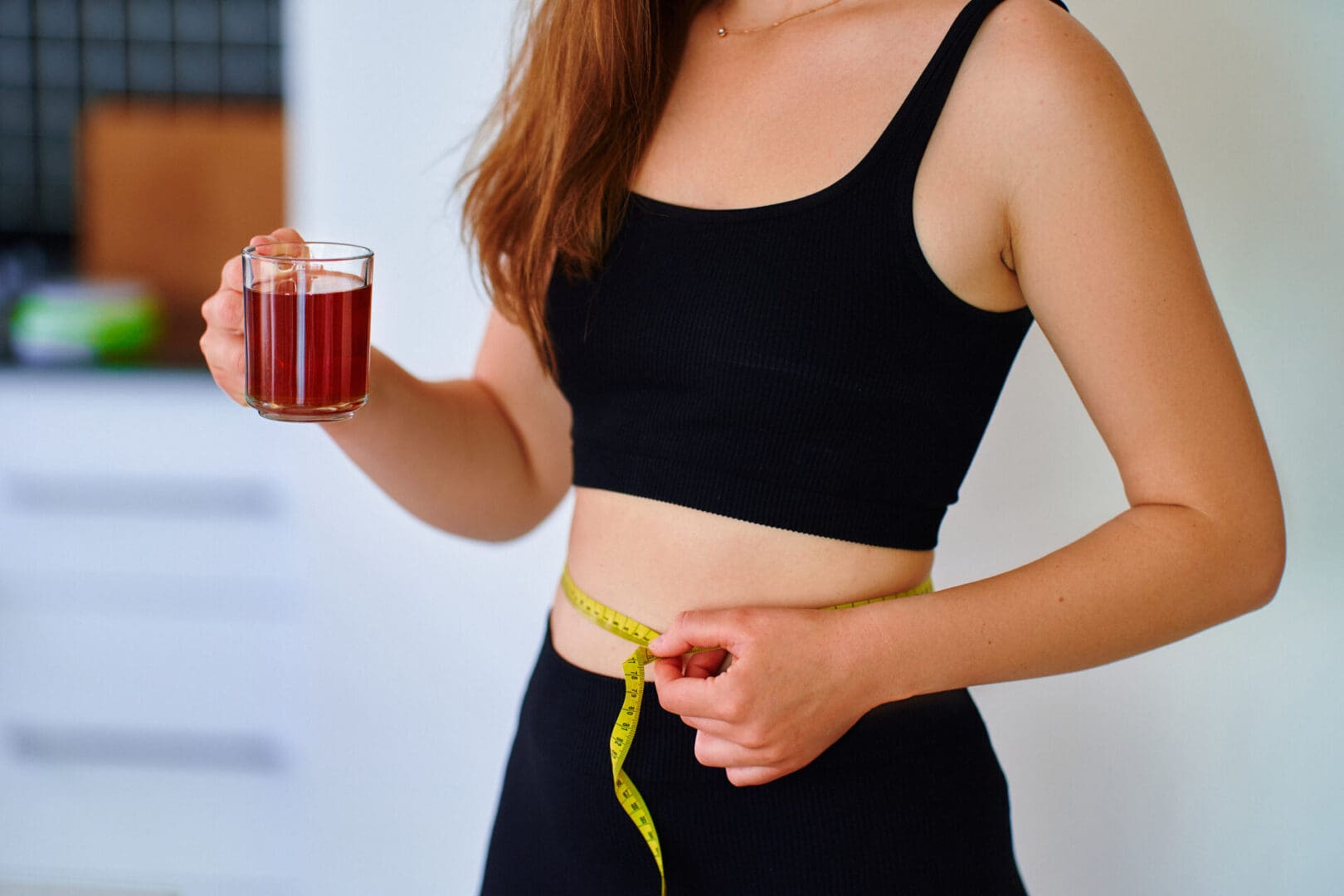 Fitness sportive healthy woman drinking herbal tea for weight loss and slimness body